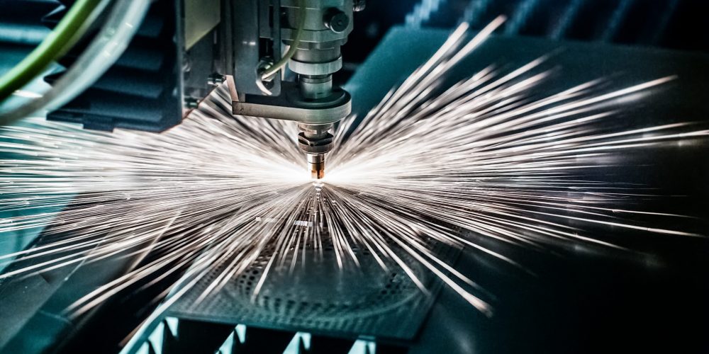 CNC Laser cutting of metal, modern industrial technology. Small depth of field. Warning - authentic shooting in challenging conditions. A little bit grain and maybe blurred.